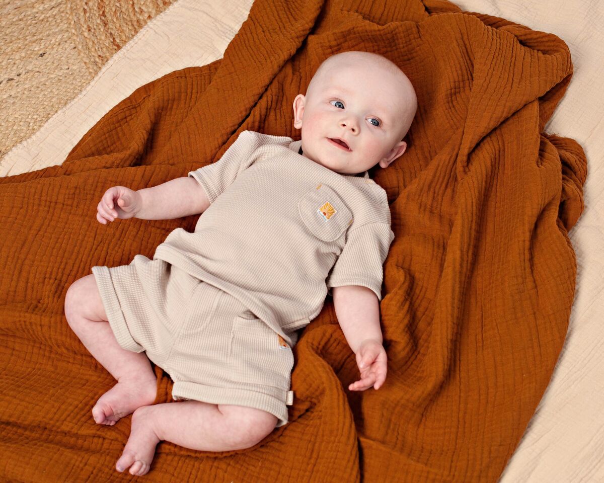 baby in zomerse waffle-set van Feetje op een warme deken